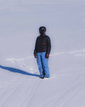Model wearing a black primaloft jacket from Union.dsgn by the slopes in Gstaad