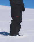 Person wearing Union.dsgn black snow pants with a visible brand logo in the snow
